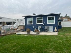 Kennewick house for rent - A blue house with a white fence and a green lawn.