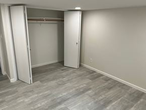 Kennewick house for rent - A room with a grey floor and white walls with two open doors.