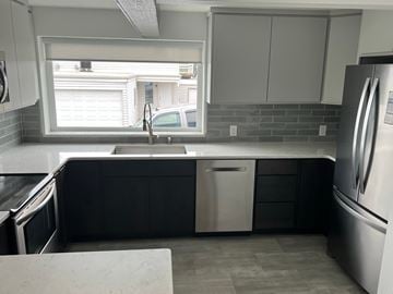 Kennewick house for rent - A kitchen with a sink, dishwasher, and refrigerator.