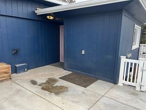 Kennewick house for rent - A blue building with a white fence and a brown door.