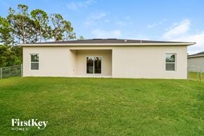 Palm Bay house for rent - A house with a white exterior and a brown roof is surrounded by a grassy lawn.
