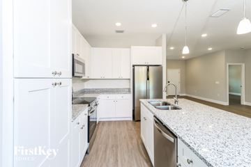 Palm Bay house for rent - A kitchen with white cabinets and a granite countertop.