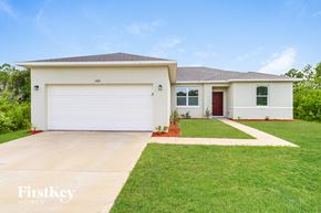 Palm Bay house for rent - A white house with a garage door numbered 1000 is for sale.
