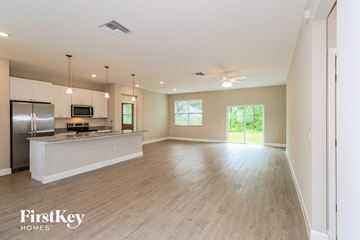 Palm Bay house for rent - A spacious kitchen with a refrigerator, microwave, and a countertop with a window.