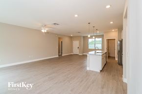 Palm Bay house for rent - A spacious room with light wood flooring and a kitchenette in the corner.