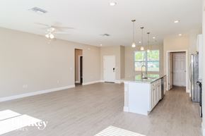 Palm Bay house for rent - A spacious kitchen and living room with a ceiling fan and pendant lights.