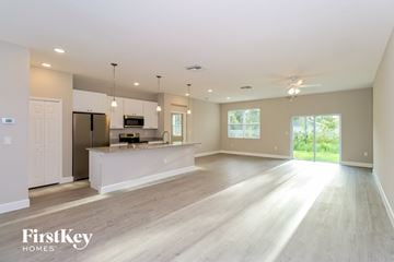 Palm Bay house for rent - A spacious kitchen and living room with wooden floors and white walls.