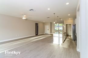 Palm Bay house for rent - A spacious room with a light-colored floor and walls, and a ceiling fan with lights.