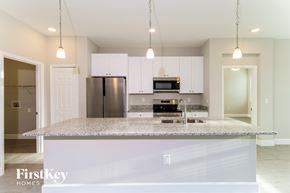 Palm Bay house for rent - A kitchen with a granite countertop and stainless steel appliances.
