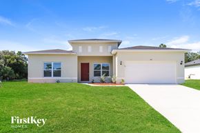 Palm Bay house for rent - A modern house with a red door and a well-maintained lawn.
