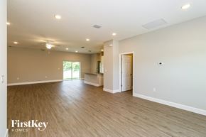 Palm Bay house for rent - A spacious room with wooden flooring and a ceiling fan.