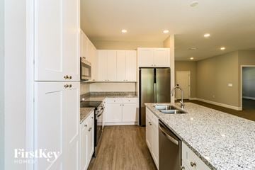 Palm Bay house for rent - A kitchen with white cabinets and a granite countertop.