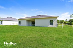 Palm Bay house for rent - A white house with a brown roof is surrounded by a grassy field.