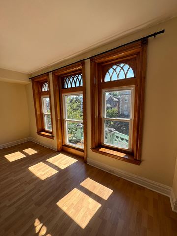 Philadelphia apartment for rent - A room with wooden floors and three windows.