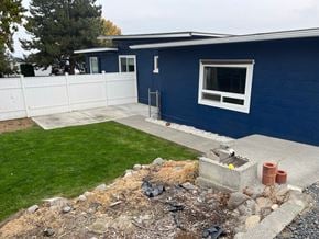Kennewick house for rent - A blue house with a white fence and a small garden.