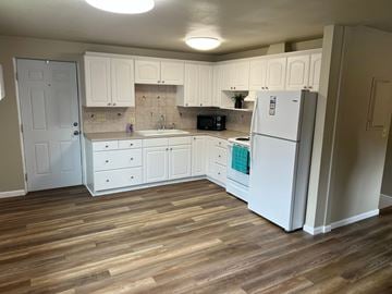 Kennewick house for rent - A kitchen with white cabinets and a white fridge.