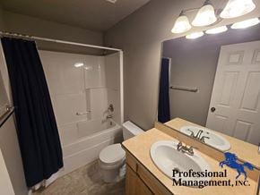 Billings house for rent - A bathroom with a toilet, sink, and mirror.