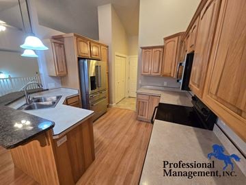 Billings house for rent - A kitchen with wooden cabinets and a granite countertop.