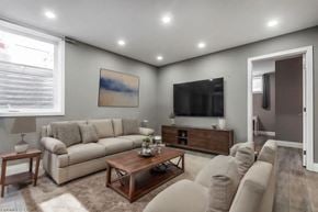 Kitchener apartment for rent - A living room with a large couch, a coffee table, and a painting on the wall.