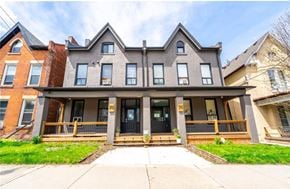 Hamilton apartment for rent - A two-story house with a black front door and a porch.