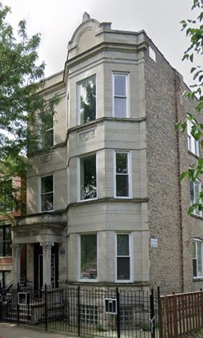 Chicago apartment for rent - A large, old building with a black iron fence in front.