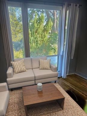 Cambridge house for rent - A living room with a couch, a coffee table, and a window with curtains.