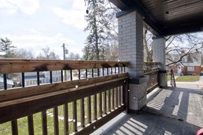 New Dundee apartment for rent - A wooden deck with a railing and a brick pillar.