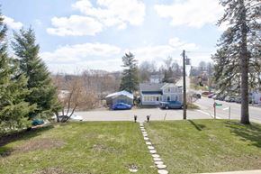 New Dundee apartment for rent - A white house with a blue car parked in front.