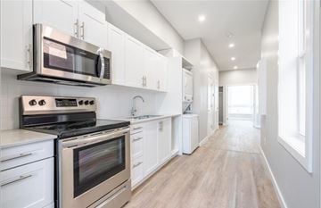 Hamilton apartment for rent - A modern kitchen with white cabinets and stainless steel appliances.