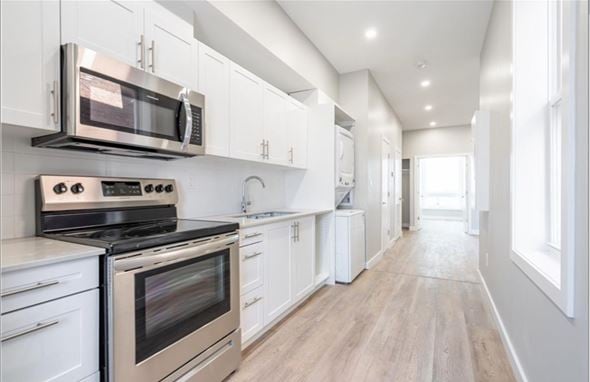Hamilton apartment for rent - A modern kitchen with white cabinets and stainless steel appliances.