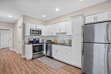 Shelton apartment for rent - A kitchen with white cabinets and a stainless steel refrigerator.
