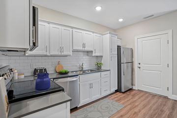 Shelton apartment for rent - A kitchen with white cabinets and a black stove top.