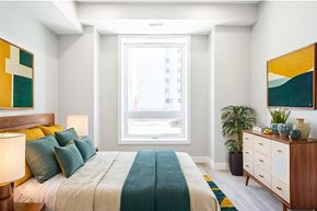 Hamilton apartment for rent - A bedroom with a bed, nightstand, and a painting on the wall.
