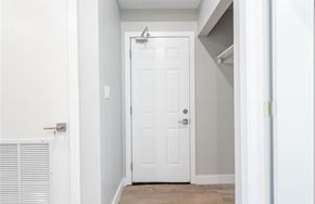 Hamilton apartment for rent - A white door is in a hallway with a light switch on the wall.