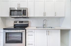 Hamilton apartment for rent - A kitchen with white cabinets and appliances.