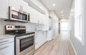 Hamilton apartment for rent - A modern kitchen with white cabinets and stainless steel appliances.