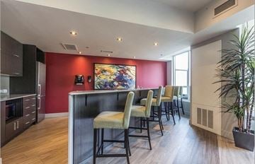 Cambridge house for rent - A kitchen with a red wall and a painting on it.