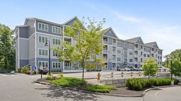 Shelton apartment for rent - A large multi-story building with a parking lot in front.