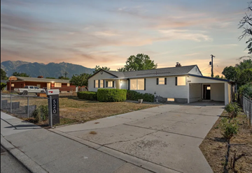 Sandy house for rent - A house numbered 520 is shown with a driveway and a mountain in the background.