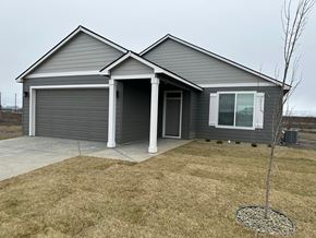 Grandview house for rent - A grey house with a white door and a small tree in front.