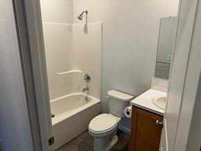 Grandview house for rent - A white toilet sits next to a bathtub in a bathroom.