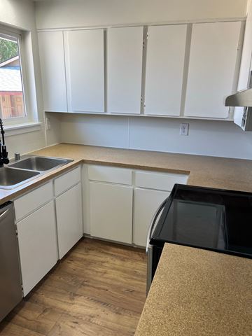Benton City apartment for rent - A kitchen with white cabinets and a black oven.