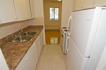 Ajax apartment for rent - A kitchen with white appliances and brown granite countertops.