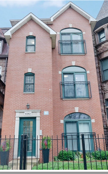 Chicago apartment for rent - A red brick building with a green door and windows.