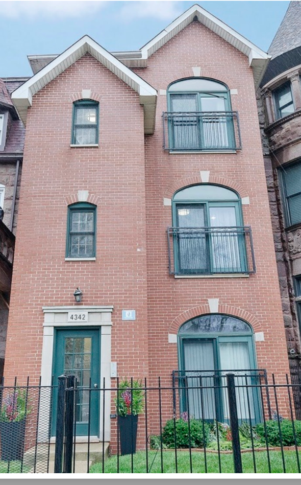 Chicago apartment for rent - A red brick building with a green door and windows.
