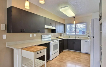 Moorhead house for rent - A kitchen with white cabinets and black countertops.