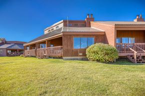 Pagosa Springs apartment for rent - A house with a brown wooden exterior and a green lawn in front.