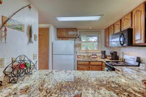 Pagosa Springs apartment for rent - A kitchen with granite countertops and wooden cabinets.