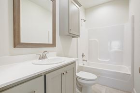 Youngsville house for rent - A white bathroom with a sink, toilet, and bathtub.
