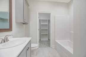 Youngsville house for rent - A white bathroom with a sink, toilet, and bathtub.